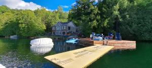 Tranquil Comforts في Val des Monts: منزل على بحيرة مع قارب في الماء