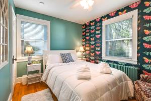a bedroom with two beds and green walls at Colorful Roanoke Vacation Rental with Hot Tub! in Roanoke