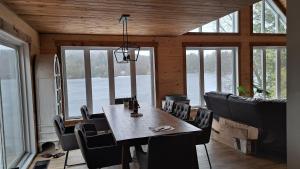 Tranquil Comforts في Val des Monts: غرفة طعام مع طاولة وكراسي ونوافذ