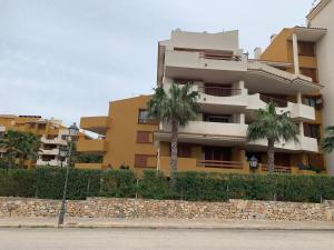 een gebouw met palmbomen ervoor bij Apartment in Punta Prima (Torrevieja) 200m to Sea in Punta Prima