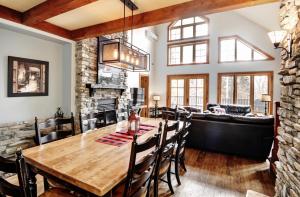 a dining room and living room with a table and a couch at Chalets Alpins- 39 Chemin des Skieurs in Stoneham