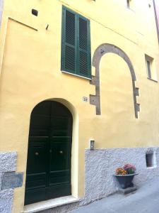 un bâtiment avec une porte, une fenêtre et un pot de fleurs dans l'établissement Casa Gialla, à Canino