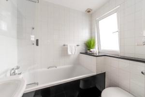 a white bathroom with a tub and a sink at The Secret KENSINGTON Garden Mews-2 Bedroom FULL HOUSE-2 Train Lines- SPACIOUS-Kings Road- Harrods -Chelsea Stadium-PRIVATE small patio in London