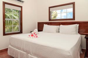 a bedroom with a white bed with a stuffed animal on it at X'tan Ha- The Waterfront in San Pedro