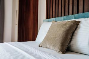 Una cama blanca con una almohada encima. en Skyline Apartments by In Property en Bečići