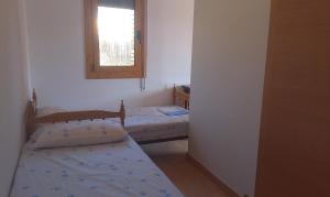 two beds in a small room with a window at Holiday Home El Romani in Calafell