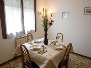 una mesa de comedor con un jarrón de flores. en I like Venice, en Mestre