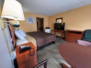 a hotel room with a bed and a television at College Inn Spartanburg in Spartanburg