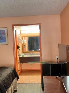 1 dormitorio con cama, espejo y escritorio en College Inn Spartanburg, en Spartanburg