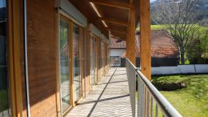 une terrasse couverte en bois d'une maison avec des fenêtres en verre dans l'établissement Eva Apartments - Nordkette, à Innsbruck