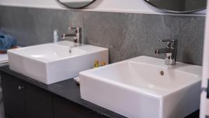 two white sinks on a counter in a bathroom at Eva Apartments - Nordkette in Innsbruck
