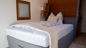 - une chambre avec un lit doté de draps blancs et une fenêtre dans l'établissement Eva Apartments - Nordkette, à Innsbruck