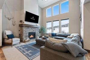 a living room with a couch and a fireplace at Bright & Spacious 4br Luxury Townhome Near Historic Park City W Fireplace & Hot Tub Noahs Retreat By Boutiq in Park City