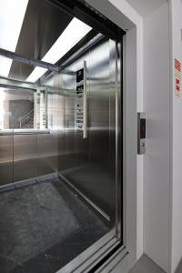 een metalen lift in een kamer met een raam bij FLH Boavista Woody Duplexes in Porto