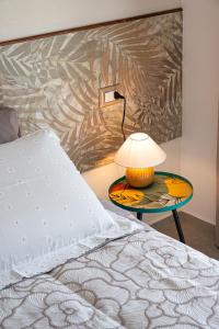 Bett mit einer Lampe auf einem Tisch neben einem Bett in der Unterkunft AgriBio Villa Ribes in Altamura