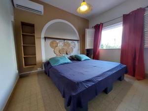 a bedroom with a large bed with a large window at KAZLETANG in Le Poteau
