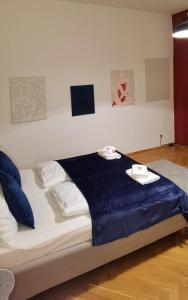 ein Bett mit blauer Bettwäsche und Handtüchern darüber in der Unterkunft Lilia in Wien