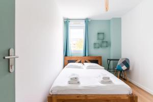 Schlafzimmer mit einem Bett mit weißer Bettwäsche und einem Fenster in der Unterkunft La Tanière de la Loire-3Ch/Ile de Nantes- Crapa in Nantes