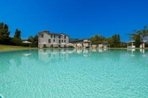 een groot zwembad met water voor een huis bij Iumara Dimora di Campagna in Omignano Scale