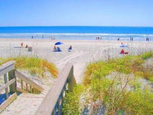 a view of a beach with people sitting under umbrellas at Beach Side complex B23 1 Bed 1 Bath w/Heated Pool in Saint Augustine