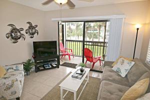 een woonkamer met een bank en een televisie bij Beach Side complex B23 1 Bed 1 Bath w/Heated Pool in St. Augustine