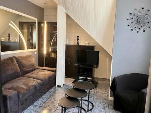 - un salon avec un canapé et une télévision dans l'établissement Cosy apartment proche Paris et Disneyland, à Gagny