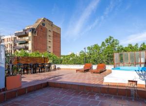un patio avec des chaises et une piscine et un bâtiment dans l'établissement Casa Palermo Soho. 2 pisos, terraza 360°, piscina y parrilla, à Buenos Aires