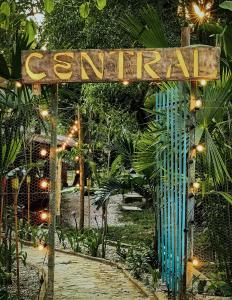 a sign for a garden with lights and a walkway at Central Minca in Minca