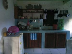 a kitchen with a refrigerator and a counter top at Chez GG in Toamasina