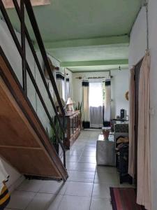 a living room with a staircase and a couch at Chez GG in Toamasina