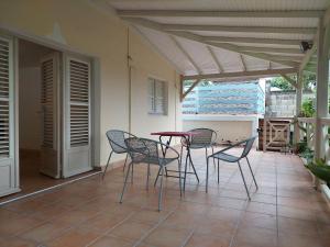 eine Terrasse mit Stühlen und einem Tisch auf der Veranda in der Unterkunft KAZLETANG in Le Poteau