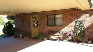 ein Backsteinhaus mit einer grünen Tür und einer Terrasse in der Unterkunft Barham Colonial Motel in Barham