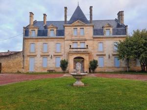 a large house with a fountain in front of it at Château Julie in Virsac