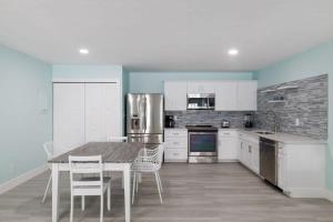 a kitchen with white cabinets and a table and chairs at Superb Bonita Springs Residence Near Downtown in Bonita Springs