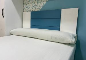 białe łóżko z niebiesko-białym zagłówkiem w obiekcie Princess resort w mieście Hurghada