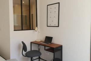 a desk with a laptop and a chair in a room at Cozy apartment near the sea in Nice