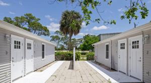 a row of white garages with a palm tree at Superb Bonita Springs Residence Near Downtown in Bonita Springs +11 photos
