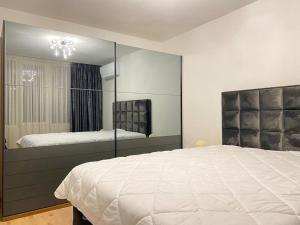 a bedroom with a large bed and a large mirror at Panorama Apartment in Plovdiv