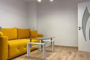a yellow couch and a table in a room at Panorama Apartment in Plovdiv