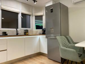 a kitchen with a refrigerator and a table and chairs at Panorama Apartment in Plovdiv