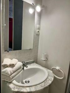 een badkamer met een wastafel, een spiegel en handdoeken bij Studio Framboise proche Paris et Disneyland in Gagny