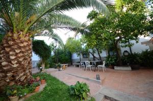 un patio con una mesa y una palmera en Casa Rural Antolina, en San Martín de Trevejo