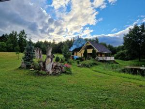 a house in the middle of a grassy field at Üleoja Saunaholiday in Kaagvere