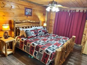 ein Schlafzimmer mit einem Bett in einem Blockhaus in der Unterkunft Stairway to Heaven - 3 Master Suite, Location, Privacy, Firepit in Gatlinburg