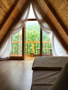 KomanにあるTwin Villas Komani Lakeのベッドルーム1室(ベッド1台、大きな窓付)