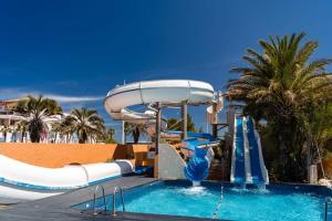 a pool with a water slide in a resort at Mobil-home Le cocon FUN PASS NON INCLUS in Canet-en-Roussillon