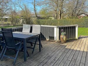 una terraza de madera con mesa y 2 sillas en 8 person holiday home in Hemmet, en Falen