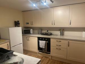 a kitchen with white cabinets and a white refrigerator at Parkside in Pateley Bridge