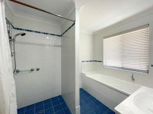 a bathroom with a shower and a tub and a sink at Seahaven - Toogoom in Toogoom +13 photos