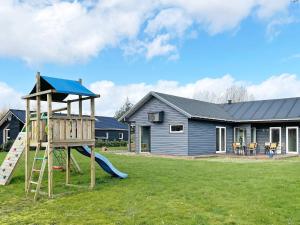 a playground with a slide and a house at 10 person holiday home in Glesborg in Glesborg
